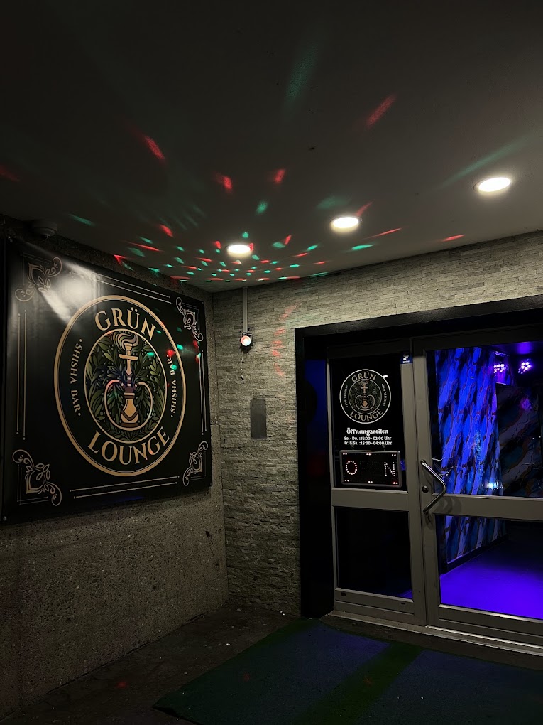 Eingang der Grün Lounge mit beleuchtetem Logo am Obertorplatz in Bremgarten