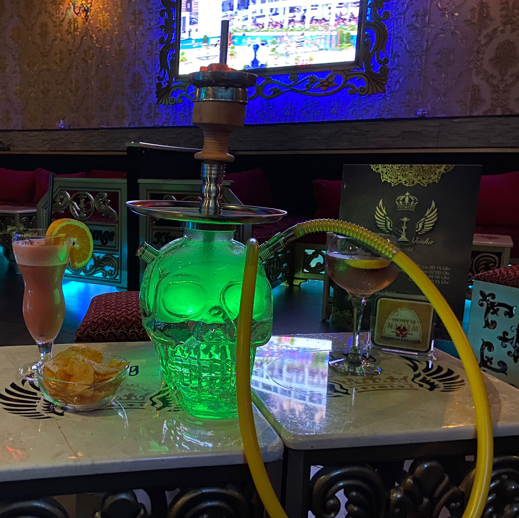 Leuchtende Totenkopf-Shisha in Grün mit Drink am Tisch der Grün Lounge