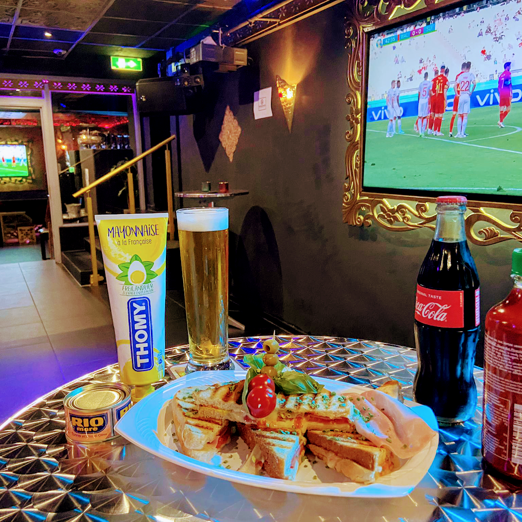 Live Fussball auf dem Bildschirm neben Snacks und Getränken in der Grün Lounge